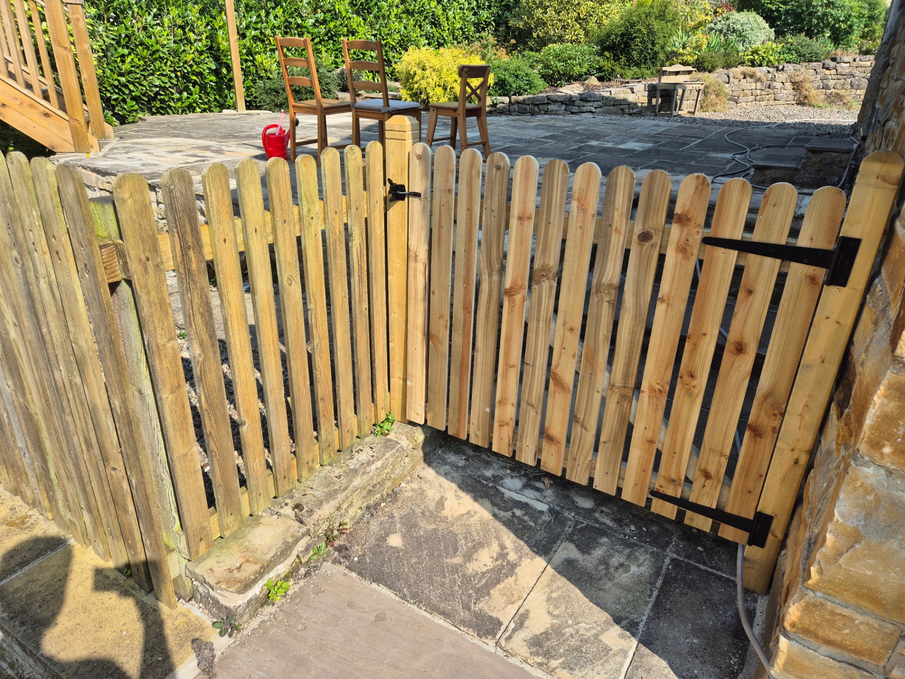 Two new wooden picket gates and a fence section matching existing fence, creating a safe patio space
